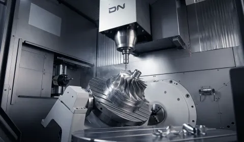 Stainless steel aerospace bracket machined on 5-axis CNC — precision bore features and fastener pattern geometry, photographed under hard directional studio lighting on dark field